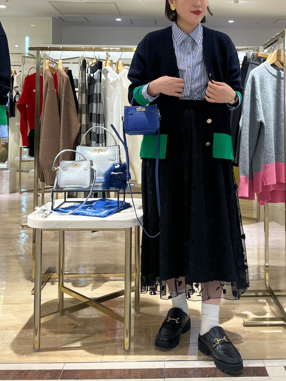 ブルー系のショルダーバッグ、ブルー系のカーディガン/ボレロ、ブルー系のシャツ/ブラウスを着用したレディースの秋コーディネートの8枚目の写真