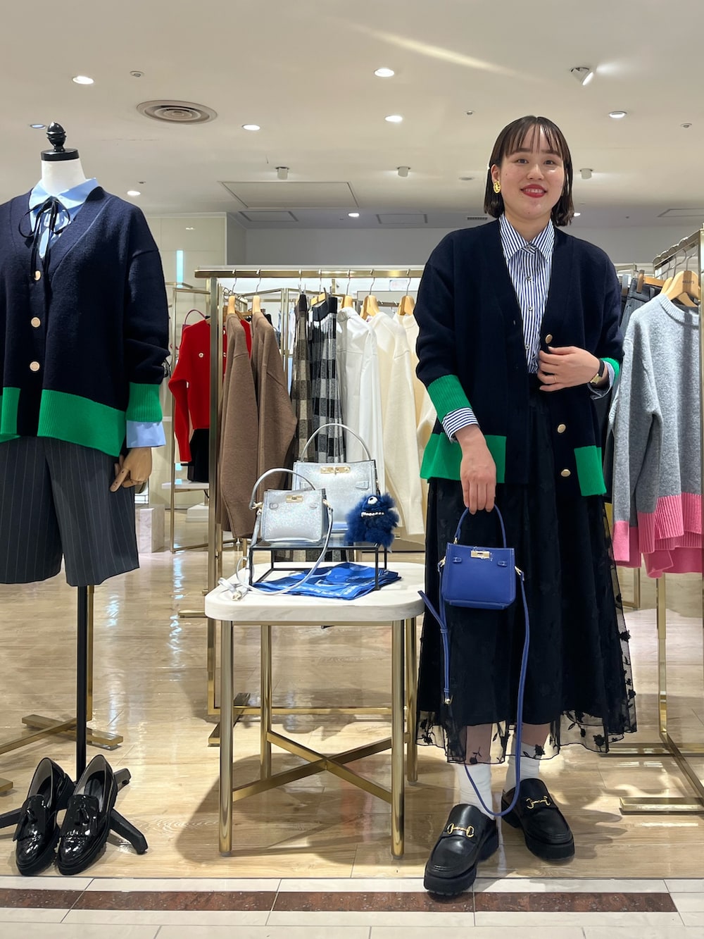 ブルー系のショルダーバッグ、ブルー系のカーディガン/ボレロ、ブルー系のシャツ/ブラウスを着用したレディースの秋コーディネートの2枚目の写真