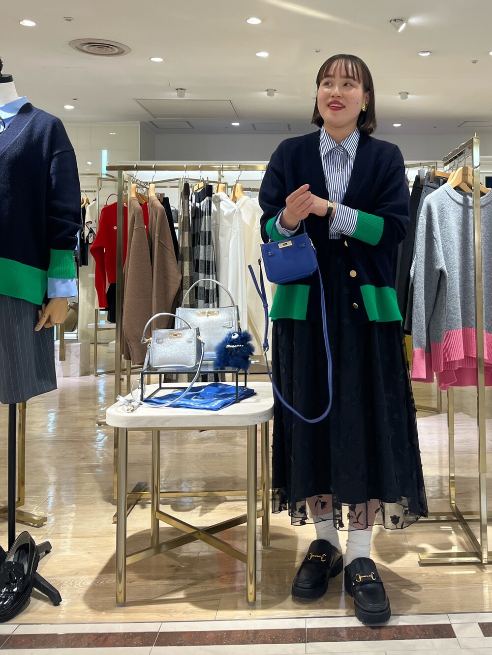 ブルー系のショルダーバッグ、ブルー系のカーディガン/ボレロ、ブルー系のシャツ/ブラウスを着用したレディースの秋コーディネートの7枚目の写真