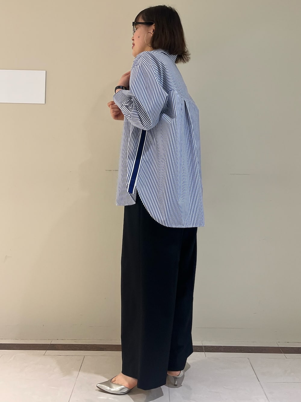 ブラック系のその他パンツ、ブルー系のシャツ/ブラウス、ブラック系のショルダーバッグを着用したレディースの春コーディネートの7枚目の写真