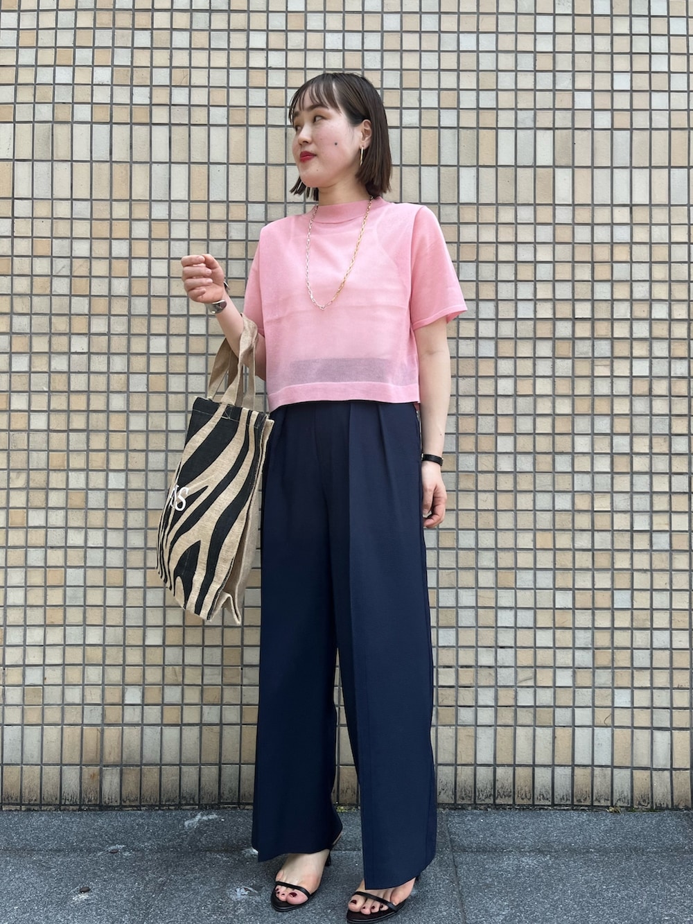 ピンク系のニット/セーター、ブルー系のその他パンツ、その他のトートバッグを着用したレディースの春コーディネートの5枚目の写真