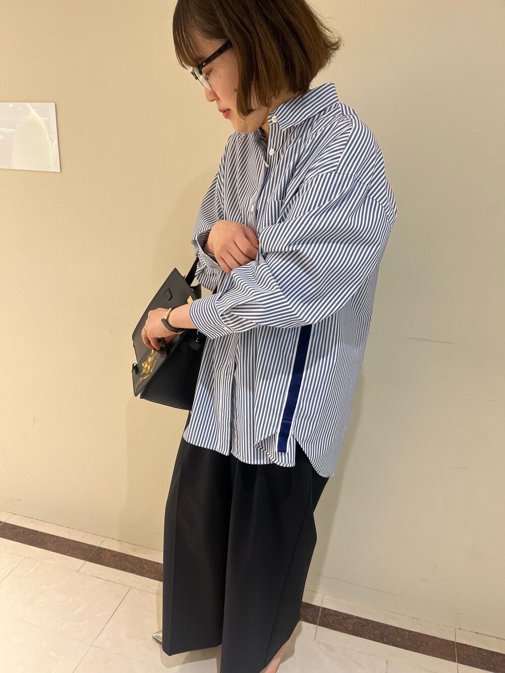 ブラック系のその他パンツ、ブルー系のシャツ/ブラウス、ブラック系のショルダーバッグを着用したレディースの春コーディネートの9枚目の写真