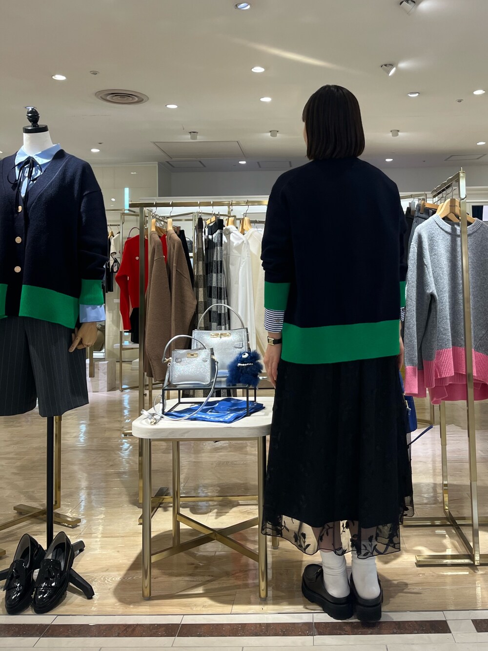 ブルー系のショルダーバッグ、ブルー系のカーディガン/ボレロ、ブルー系のシャツ/ブラウスを着用したレディースの秋コーディネートの5枚目の写真