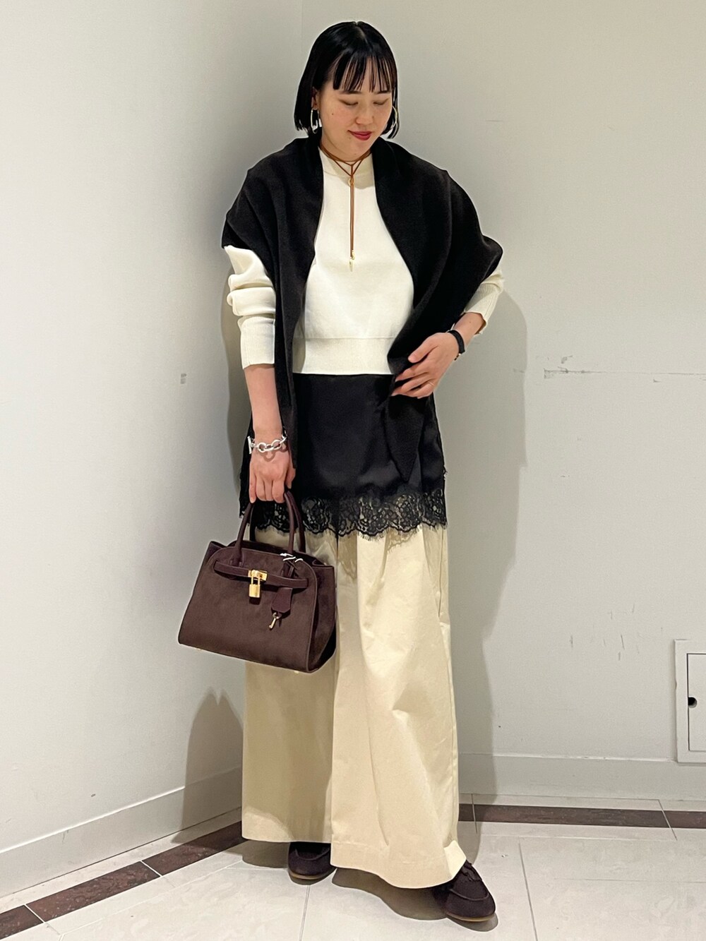 ホワイト系のニット/セーター、ホワイト系のその他パンツ、ブラウン系のトートバッグを着用したレディースの秋コーディネートの8枚目の写真