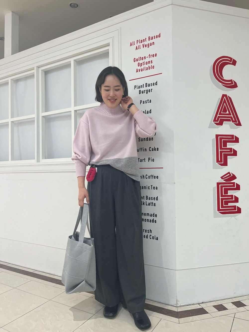 グレー系のその他パンツ、ピンク系のニット/セーター、シルバー系のトートバッグを着用したレディースの冬コーディネートの9枚目の写真