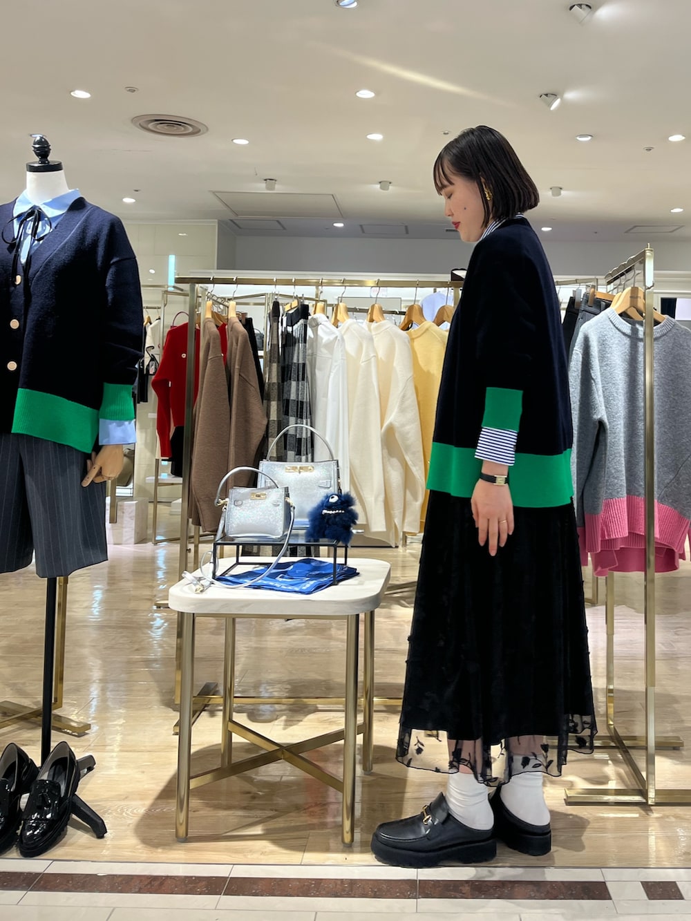 ブルー系のショルダーバッグ、ブルー系のカーディガン/ボレロ、ブルー系のシャツ/ブラウスを着用したレディースの秋コーディネートの6枚目の写真