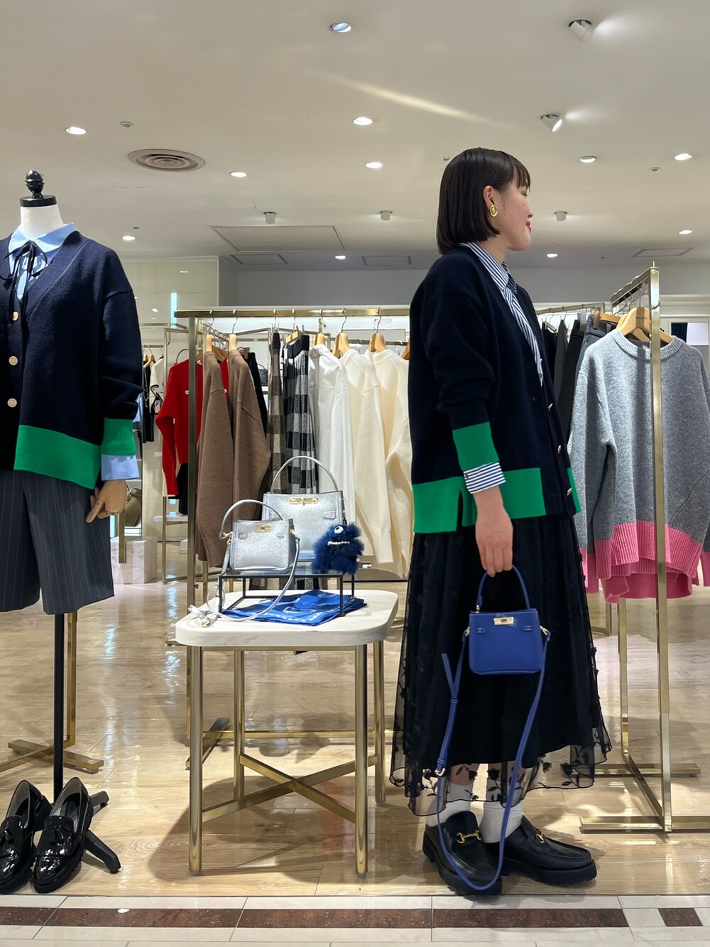 ブルー系のショルダーバッグ、ブルー系のカーディガン/ボレロ、ブルー系のシャツ/ブラウスを着用したレディースの秋コーディネートの4枚目の写真