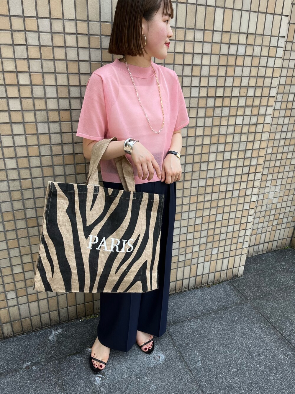 ピンク系のニット/セーター、ブルー系のその他パンツ、その他のトートバッグを着用したレディースの春コーディネートの8枚目の写真