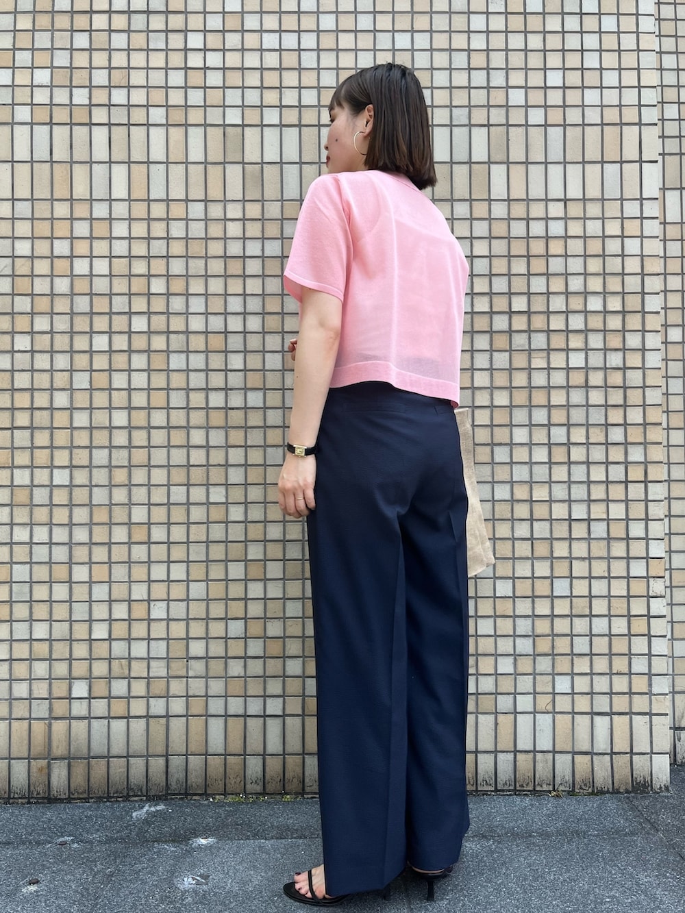 ピンク系のニット/セーター、ブルー系のその他パンツ、その他のトートバッグを着用したレディースの春コーディネートの4枚目の写真