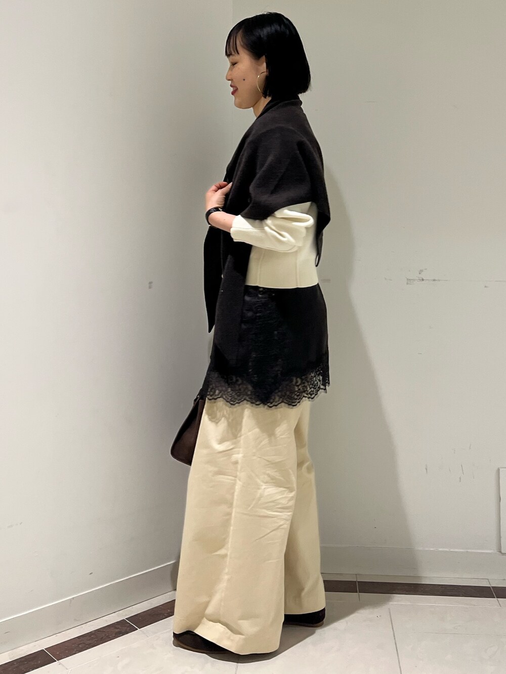 ホワイト系のニット/セーター、ホワイト系のその他パンツ、ブラウン系のトートバッグを着用したレディースの秋コーディネートの6枚目の写真