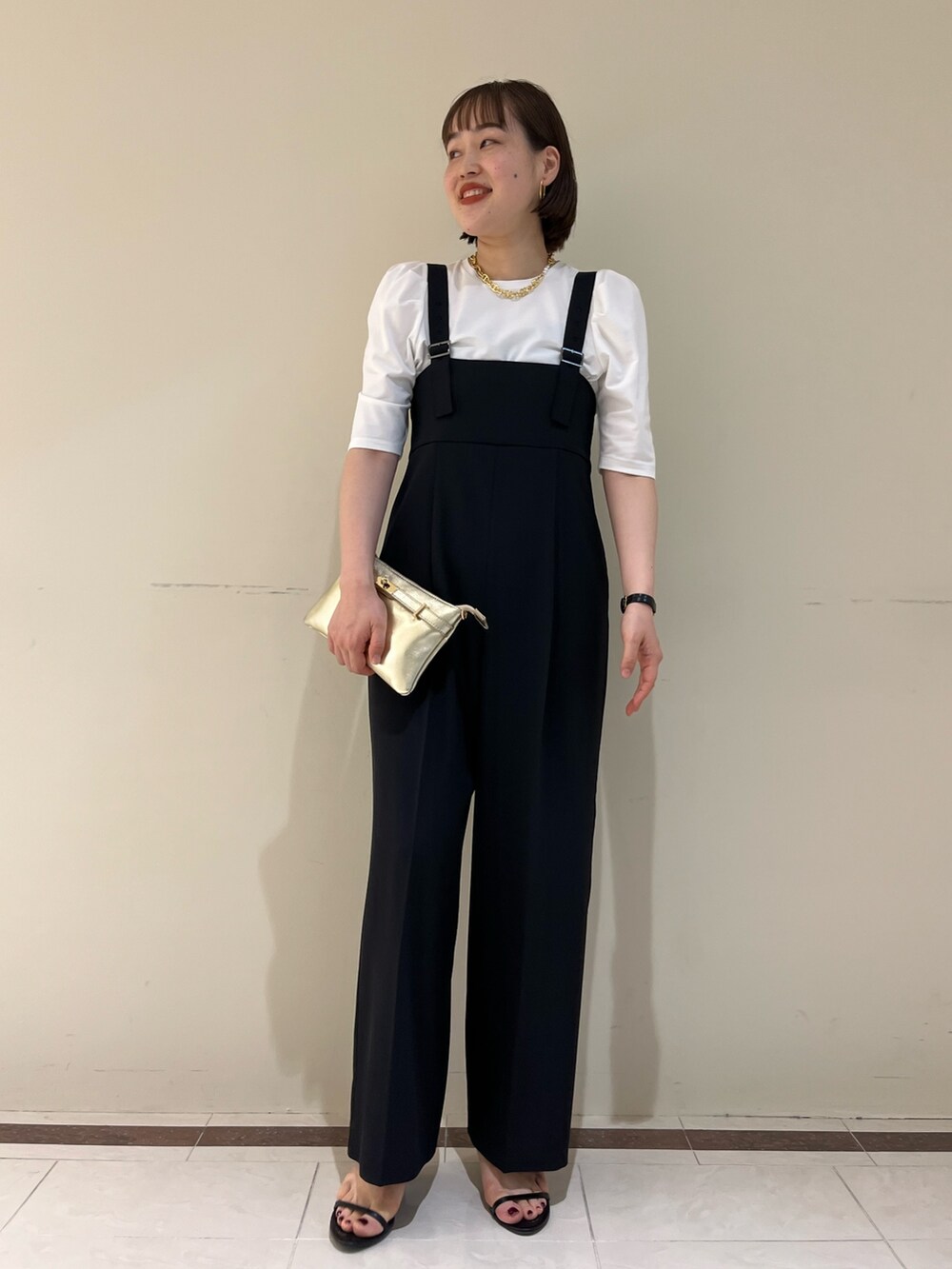 「NOLLEY'S、ノーリーズ、レイヤードスタイル、夏コーデ、きれいめカジュアル、大人かわいい、フリル、お出かけコーデ、オールインワン、サロペット、Tシャツ、モノトーン、30代コーデ、高身長女子、キレイめ」｜「NOLLEY’Sのヒネリカナグチェーンポシェット（ショルダーバッグ、ゴールド系）」を使った、SAYAKAさん（レディース・163cm）の夏コーディネートの2枚目の写真