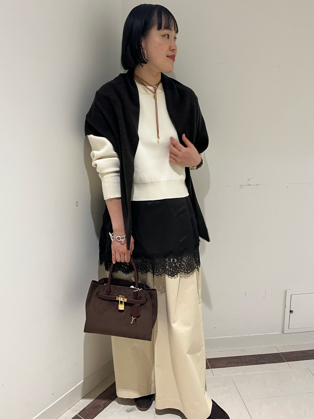 ホワイト系のニット/セーター、ホワイト系のその他パンツ、ブラウン系のトートバッグを着用したレディースの秋コーディネートの9枚目の写真