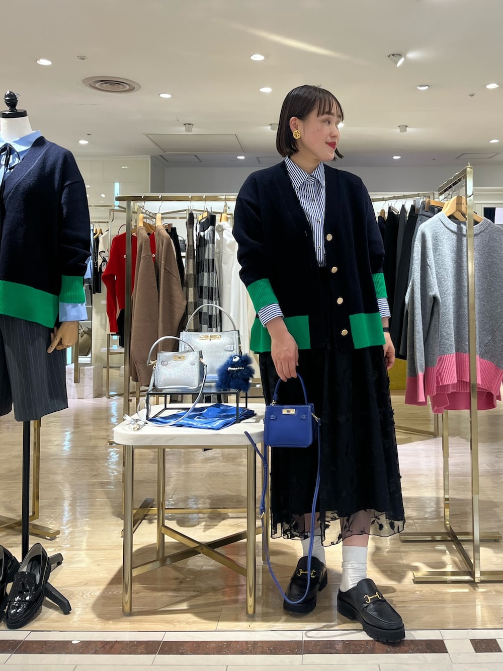 ブルー系のショルダーバッグ、ブルー系のカーディガン/ボレロ、ブルー系のシャツ/ブラウスを着用したレディースの秋コーディネートの3枚目の写真