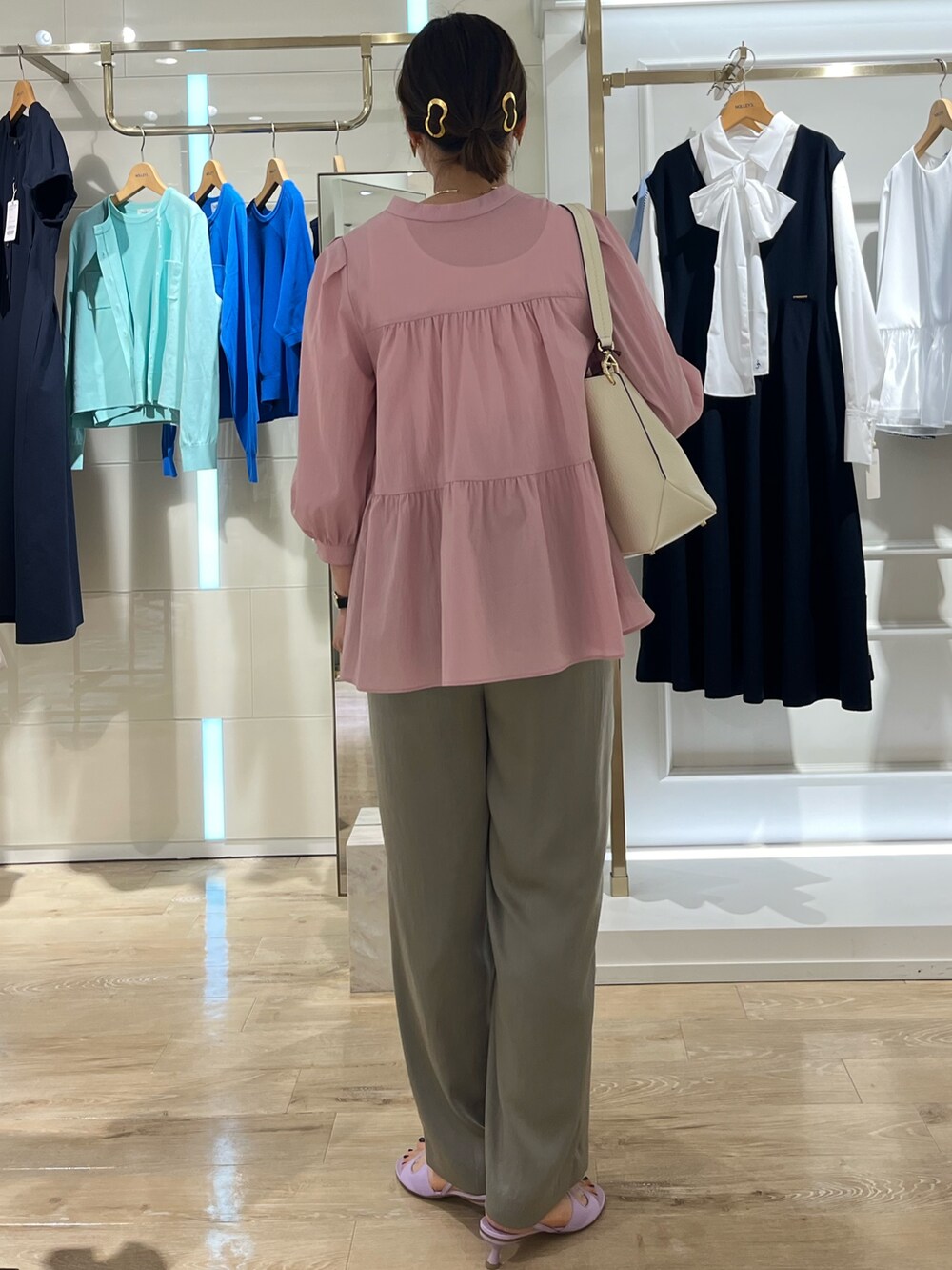 ベージュ系のその他パンツ、ホワイト系のタンクトップ、ホワイト系のショルダーバッグを着用したレディースの春コーディネートの4枚目の写真
