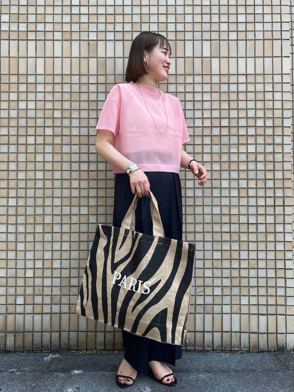 ピンク系のニット/セーター、ブルー系のその他パンツ、その他のトートバッグを着用したレディースの春コーディネートの2枚目の写真