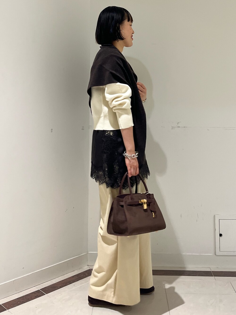 ホワイト系のニット/セーター、ホワイト系のその他パンツ、ブラウン系のトートバッグを着用したレディースの秋コーディネートの4枚目の写真