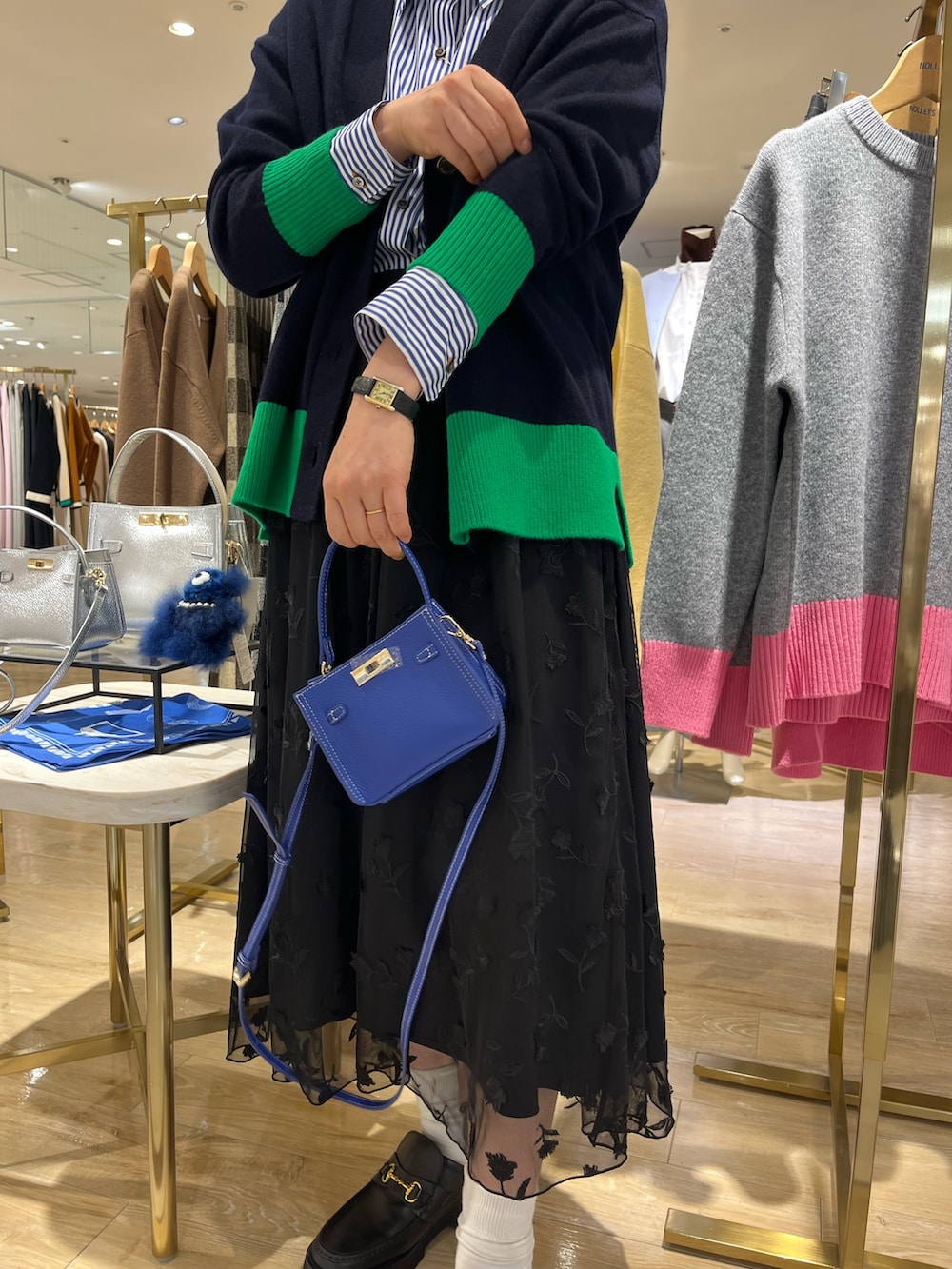 ブルー系のショルダーバッグ、ブルー系のカーディガン/ボレロ、ブルー系のシャツ/ブラウスを着用したレディースの秋コーディネートの10枚目の写真