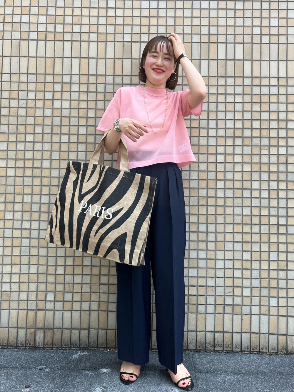 ピンク系のニット/セーター、ブルー系のその他パンツ、その他のトートバッグを着用したレディースの春コーディネートの6枚目の写真