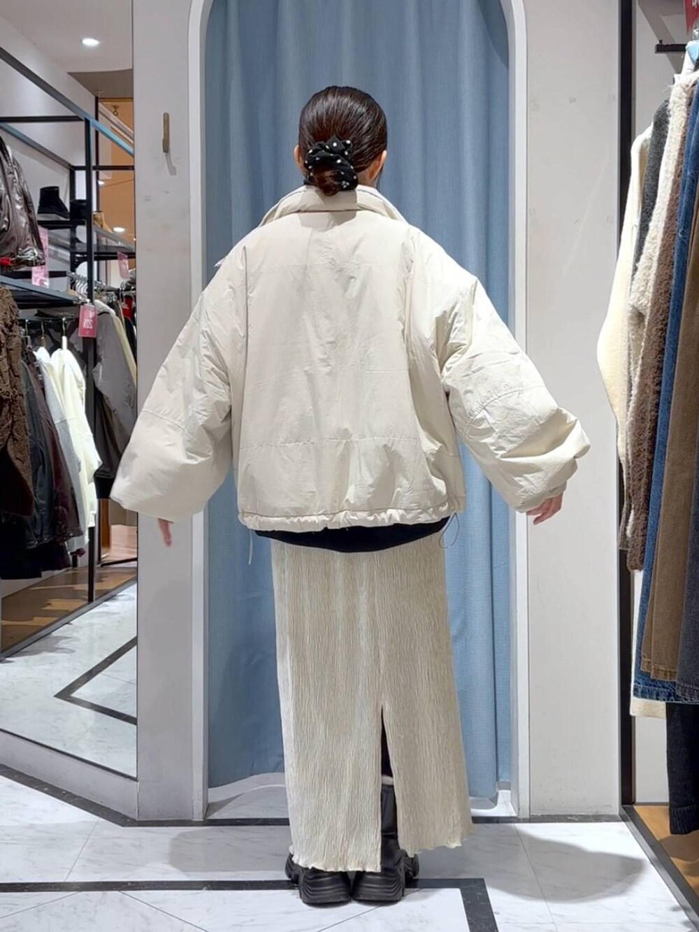 ホワイト系のその他アウター、ブラック系のブーツ、ホワイト系のスカートを着用したレディースの冬コーディネートの5枚目の写真