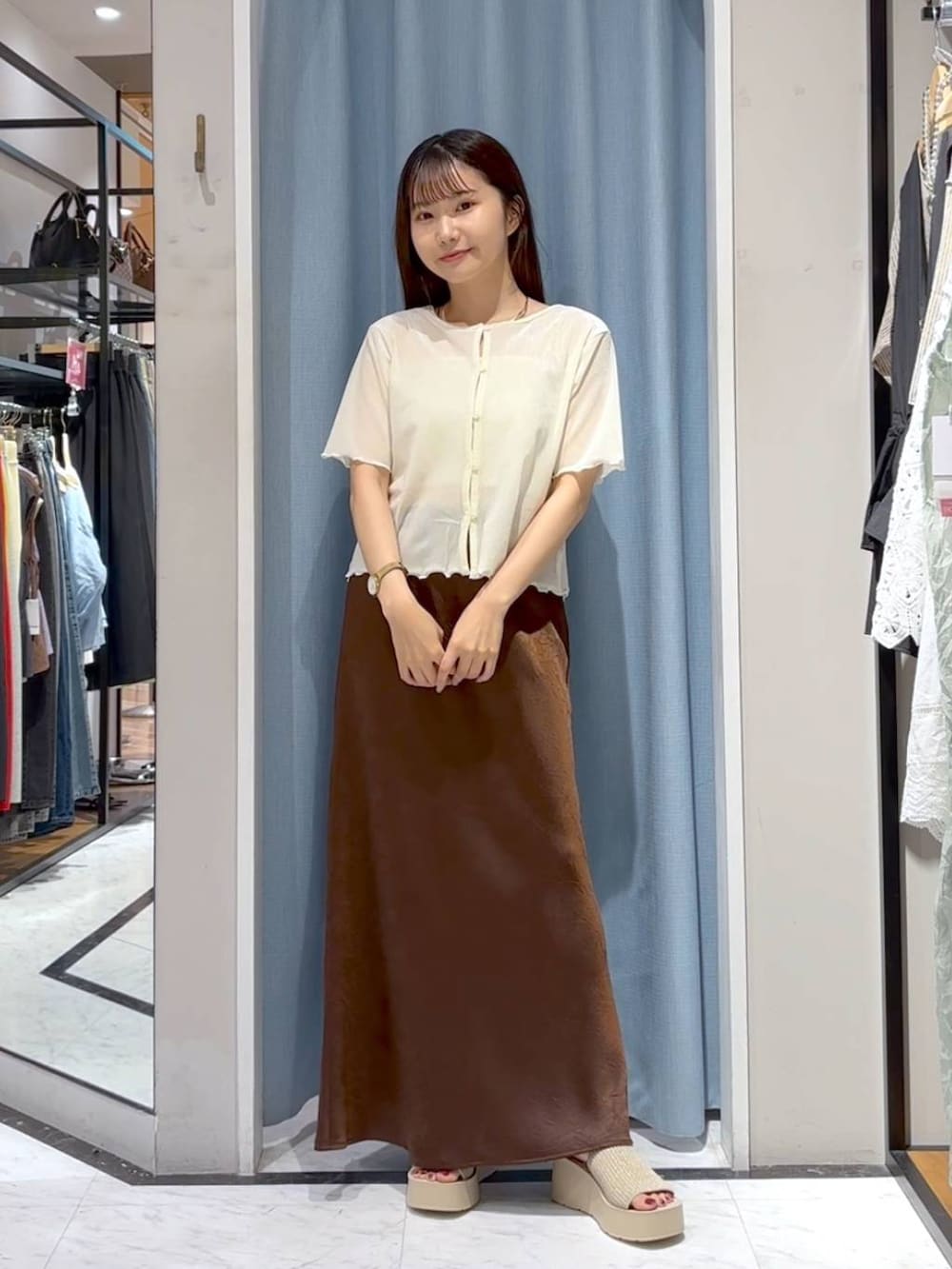 ホワイト系のTシャツ/カットソー、ホワイト系のサンダル、ブラウン系のスカートを着用したレディースの秋コーディネートの3枚目の写真
