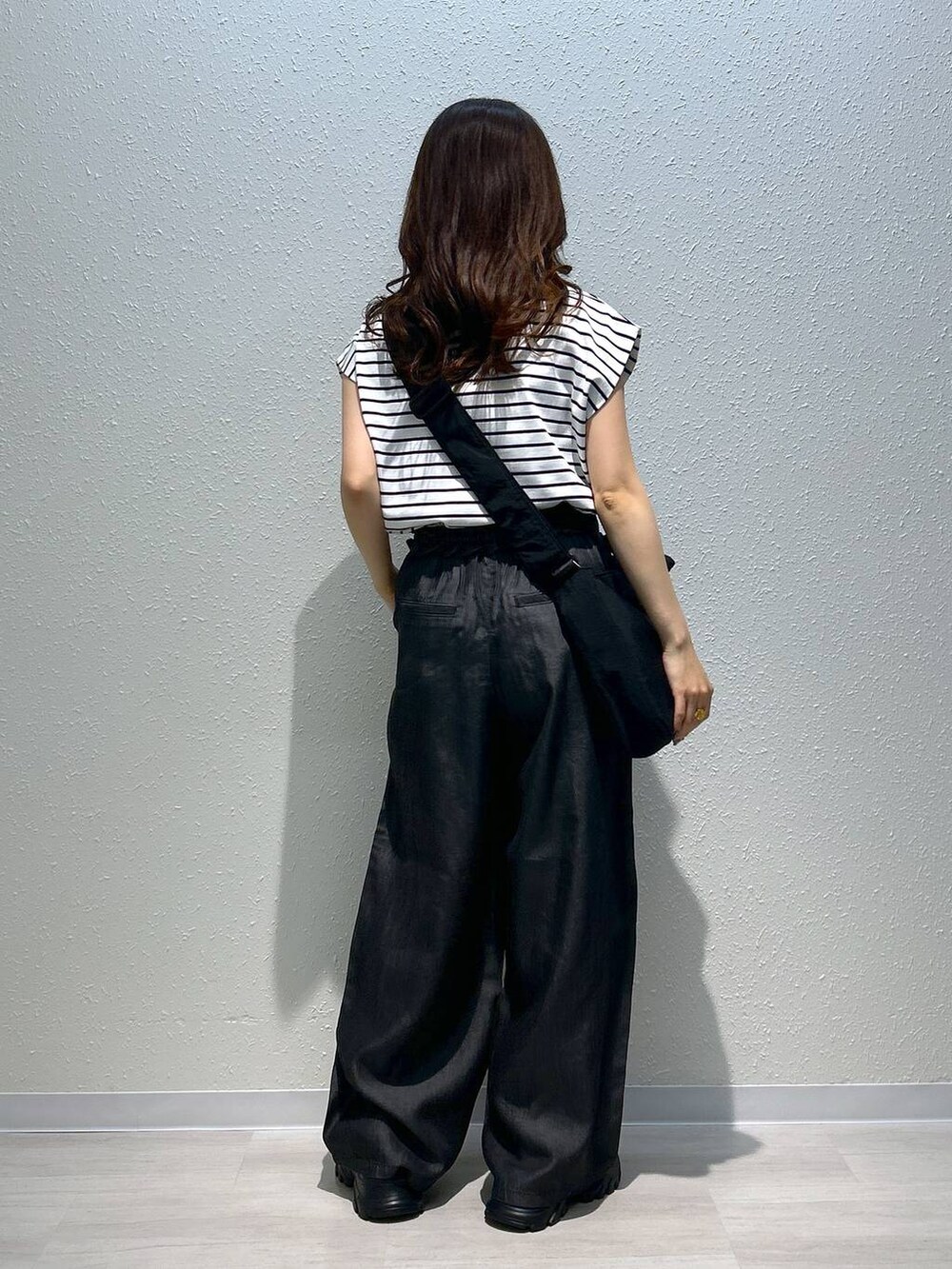 ブラック系のサンダル、ブラック系のデニムパンツ、ブラック系のTシャツ/カットソーを着用したレディースの夏コーディネートの7枚目の写真