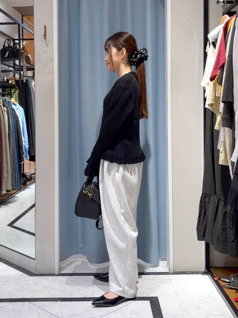 グレー系のスウェットパンツ、ブラック系のショルダーバッグ、ブラック系のニット/セーターを着用したレディースの秋コーディネートの6枚目の写真