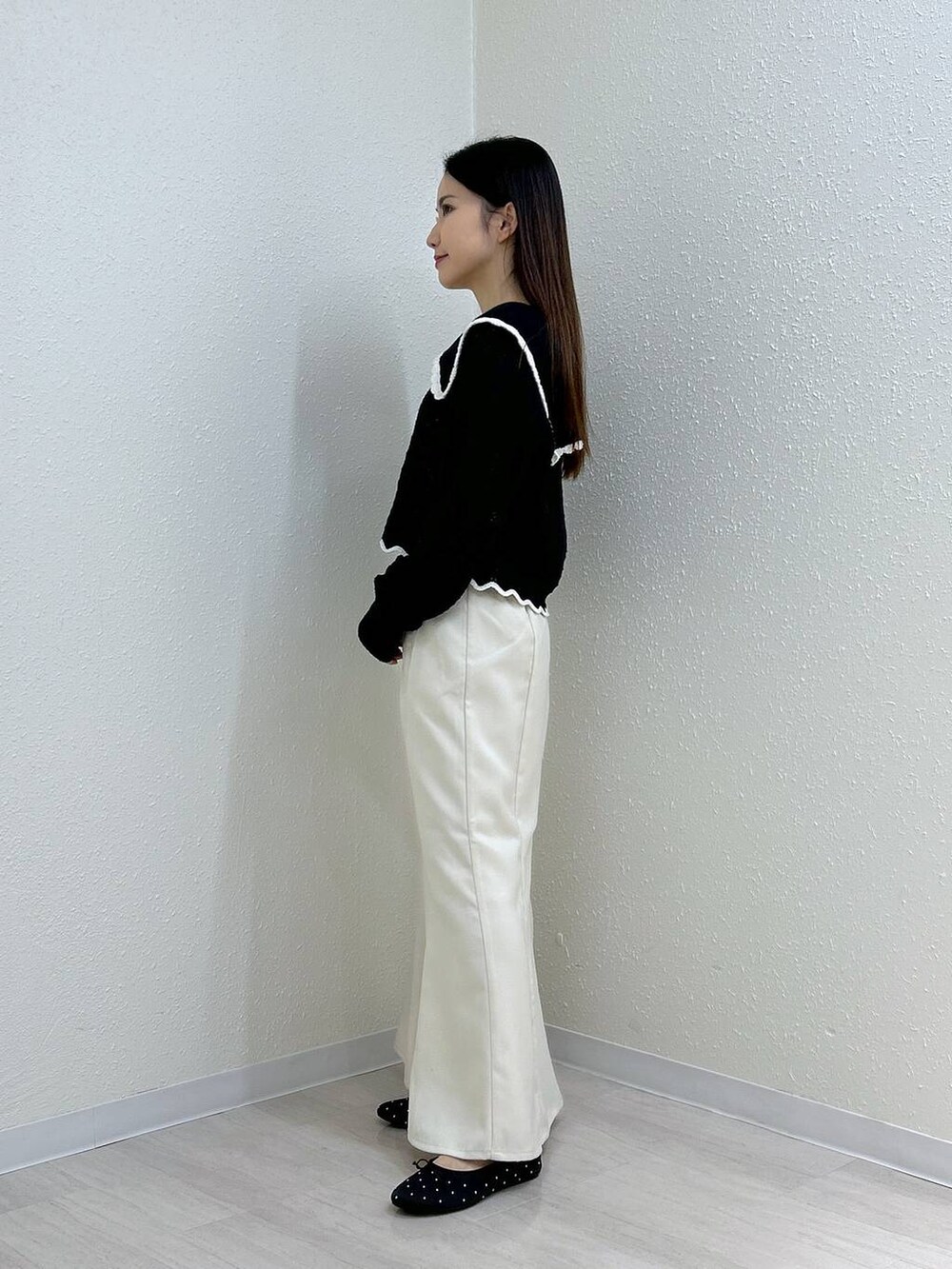 ホワイト系のスカート、ホワイト系のタンクトップ、ブラック系のバレエシューズを着用したレディースの秋コーディネートの7枚目の写真