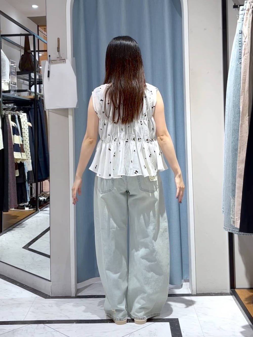 ブルー系のデニムパンツ、ホワイト系のサンダル、ホワイト系のシャツ/ブラウスを着用したレディースの夏コーディネートの6枚目の写真