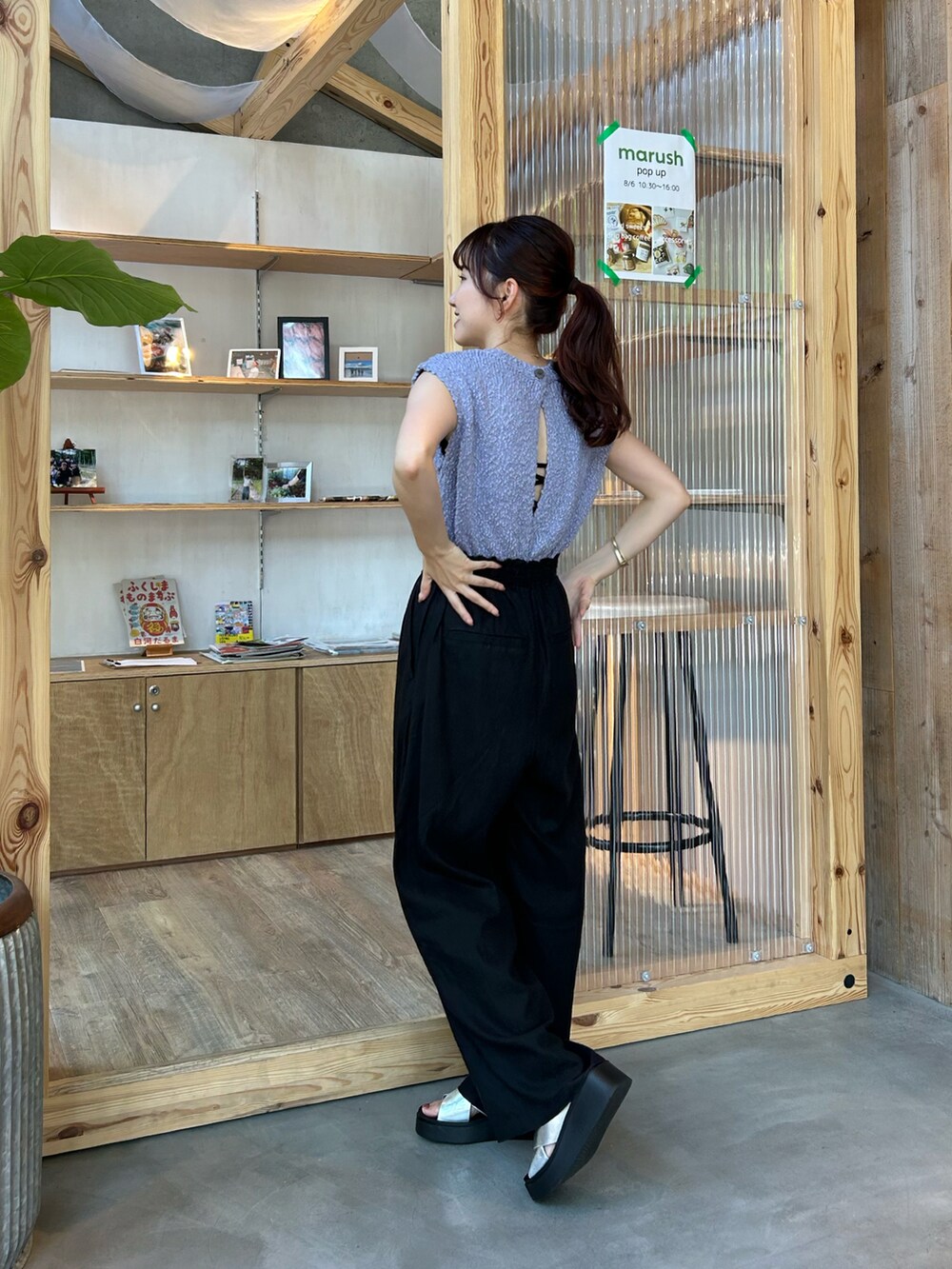 ブラック系のパンツ、パープル系のベスト、シルバー系のサンダルを着用したレディースの夏コーディネートの2枚目の写真