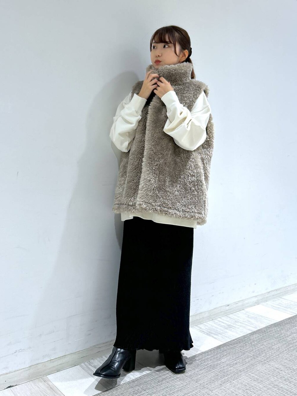 ホワイト系のブルゾン、ブラック系のパンプス、ブラック系のスカートを着用したレディースの冬コーディネートの3枚目の写真