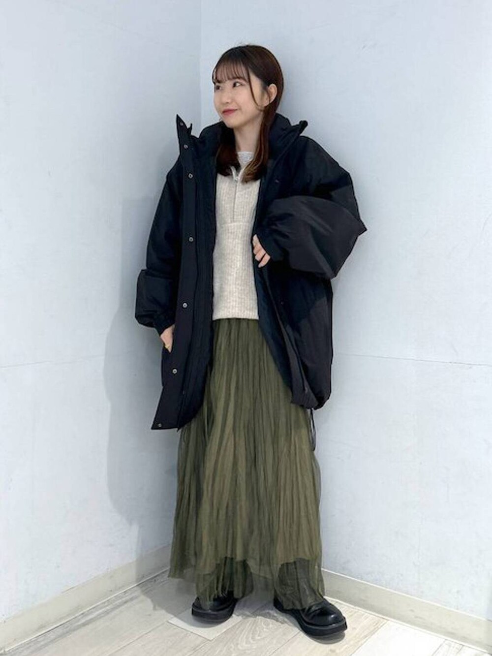 ブラック系のダウンジャケット/コート、ブラック系のブーツ、ホワイト系のTシャツ/カットソーを着用したレディースの冬コーディネートの2枚目の写真