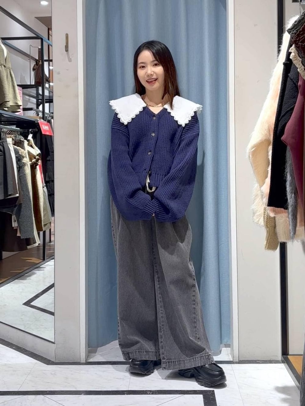 ブラック系のデニムパンツ、ブラック系のローファー、ブルー系のカーディガン/ボレロを着用したレディースの冬コーディネートの2枚目の写真