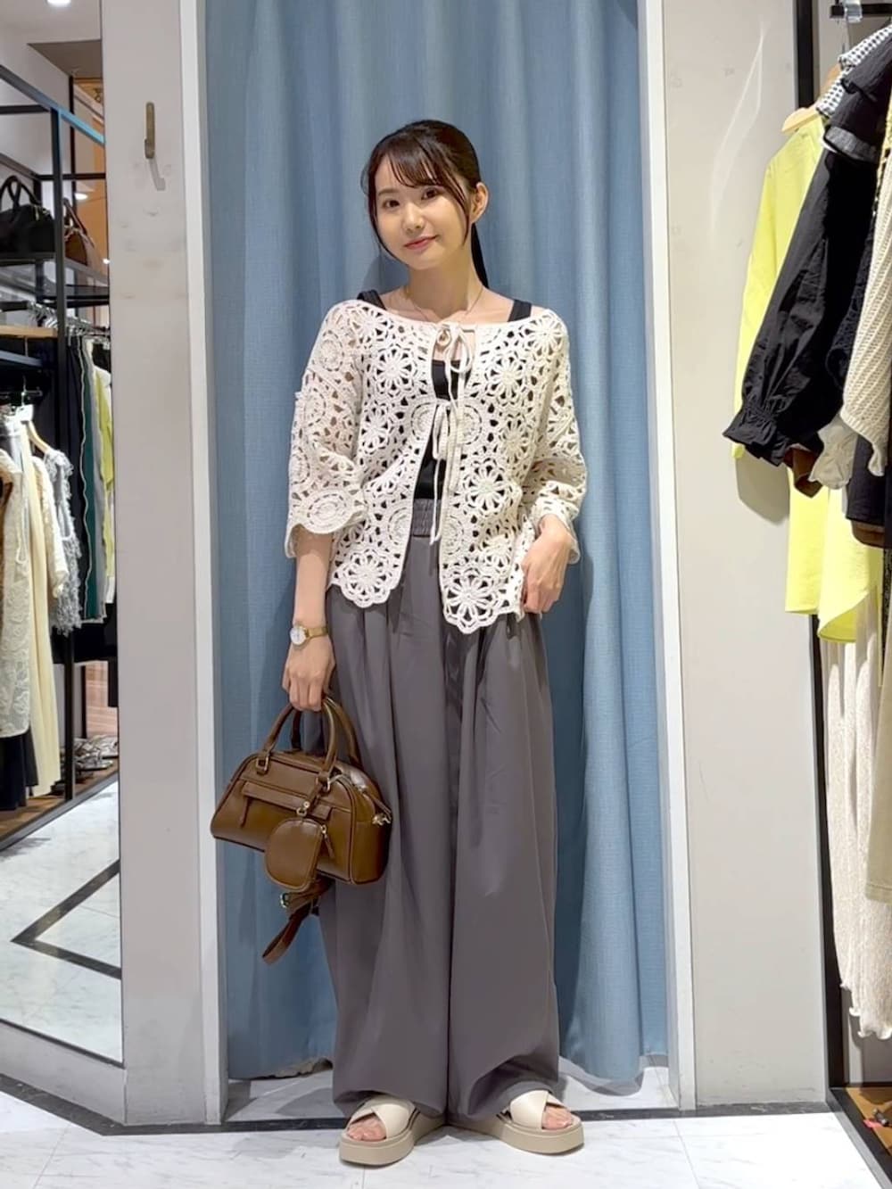 ブラック系のタンクトップ、ホワイト系のサンダル、ホワイト系のカーディガン/ボレロを着用したレディースの夏コーディネートの5枚目の写真