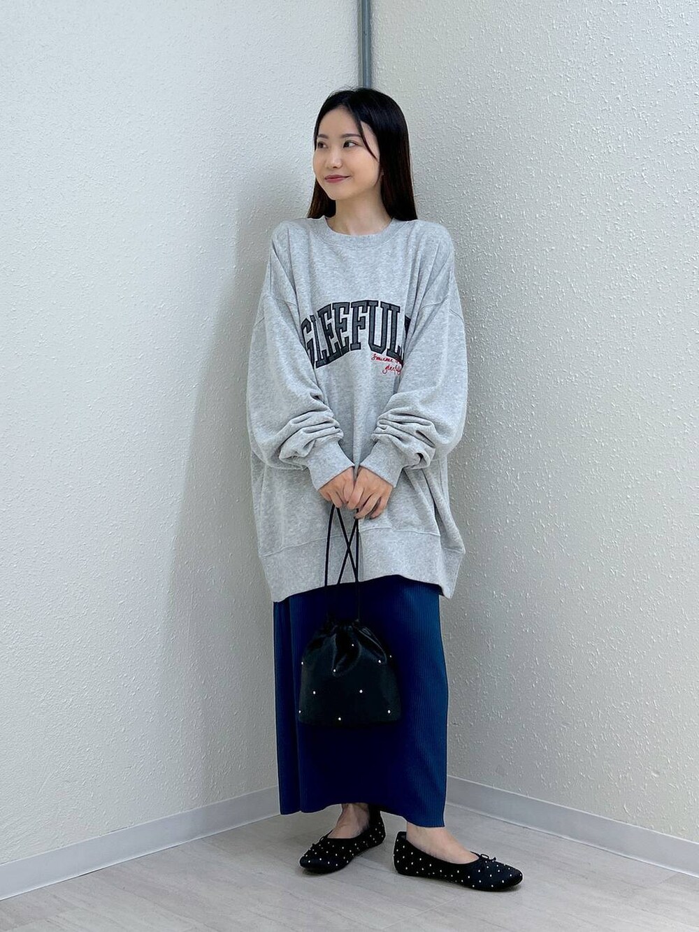 ブラック系のスカート、ブラック系のショルダーバッグ、ブラック系のバレエシューズを着用したレディースの秋コーディネートの2枚目の写真