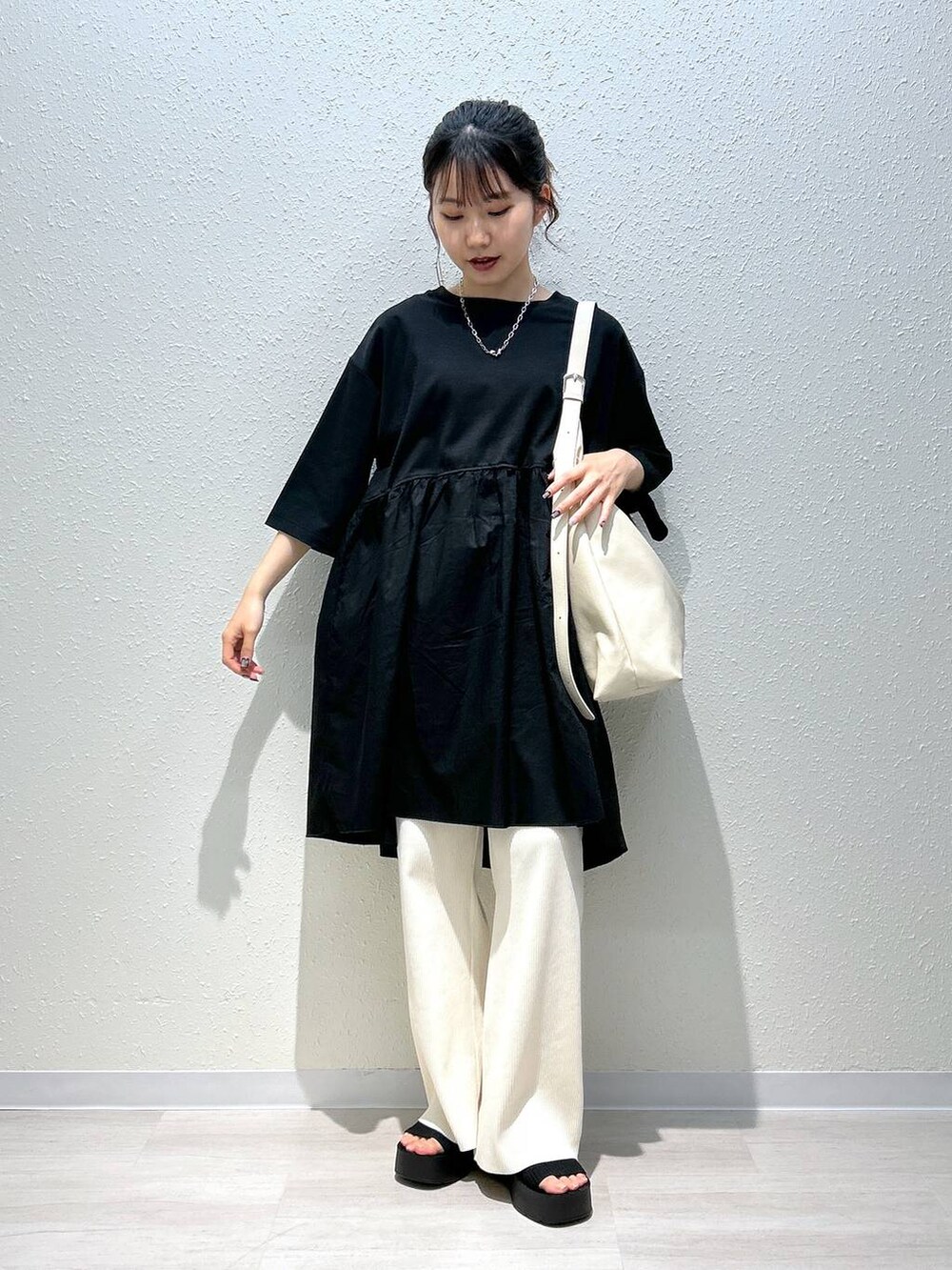ブラック系のサンダル、ホワイト系のその他パンツ、ブラック系のTシャツ/カットソーを着用したレディースの春コーディネートの4枚目の写真