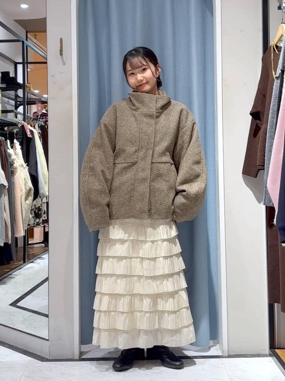 ベージュ系のブルゾン、ホワイト系のスカート、ブラウン系のニット/セーターを着用したレディースの冬コーディネートの6枚目の写真