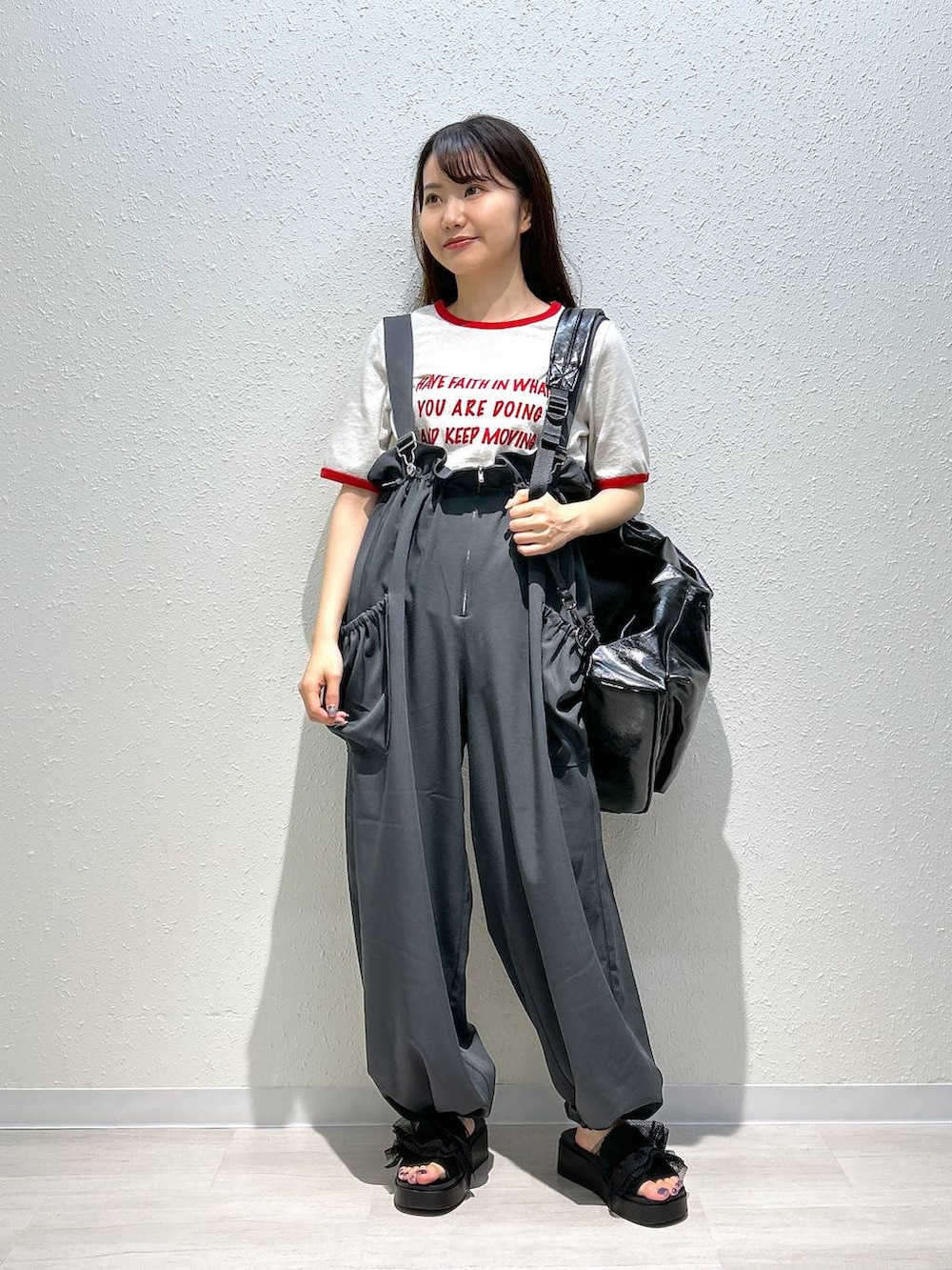 ブラック系のサンダル、ホワイト系のTシャツ/カットソー、ブラック系のショルダーバッグを着用したレディースの夏コーディネートの2枚目の写真