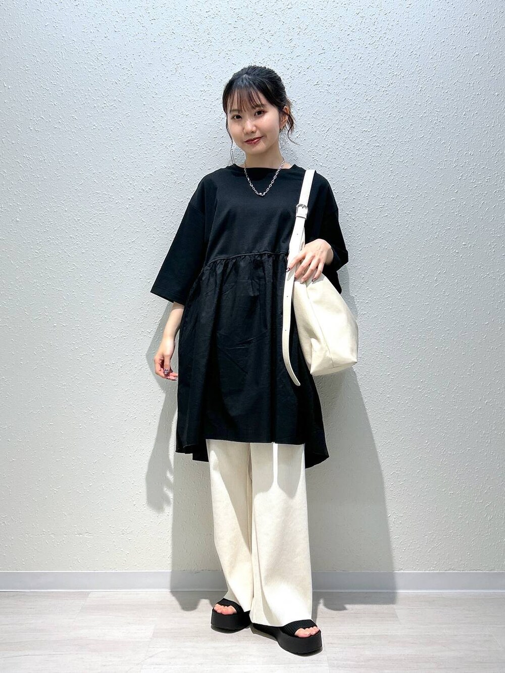 ブラック系のサンダル、ホワイト系のその他パンツ、ブラック系のTシャツ/カットソーを着用したレディースの春コーディネートの5枚目の写真