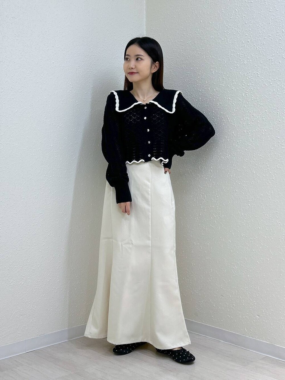 ホワイト系のスカート、ホワイト系のタンクトップ、ブラック系のバレエシューズを着用したレディースの秋コーディネートの2枚目の写真