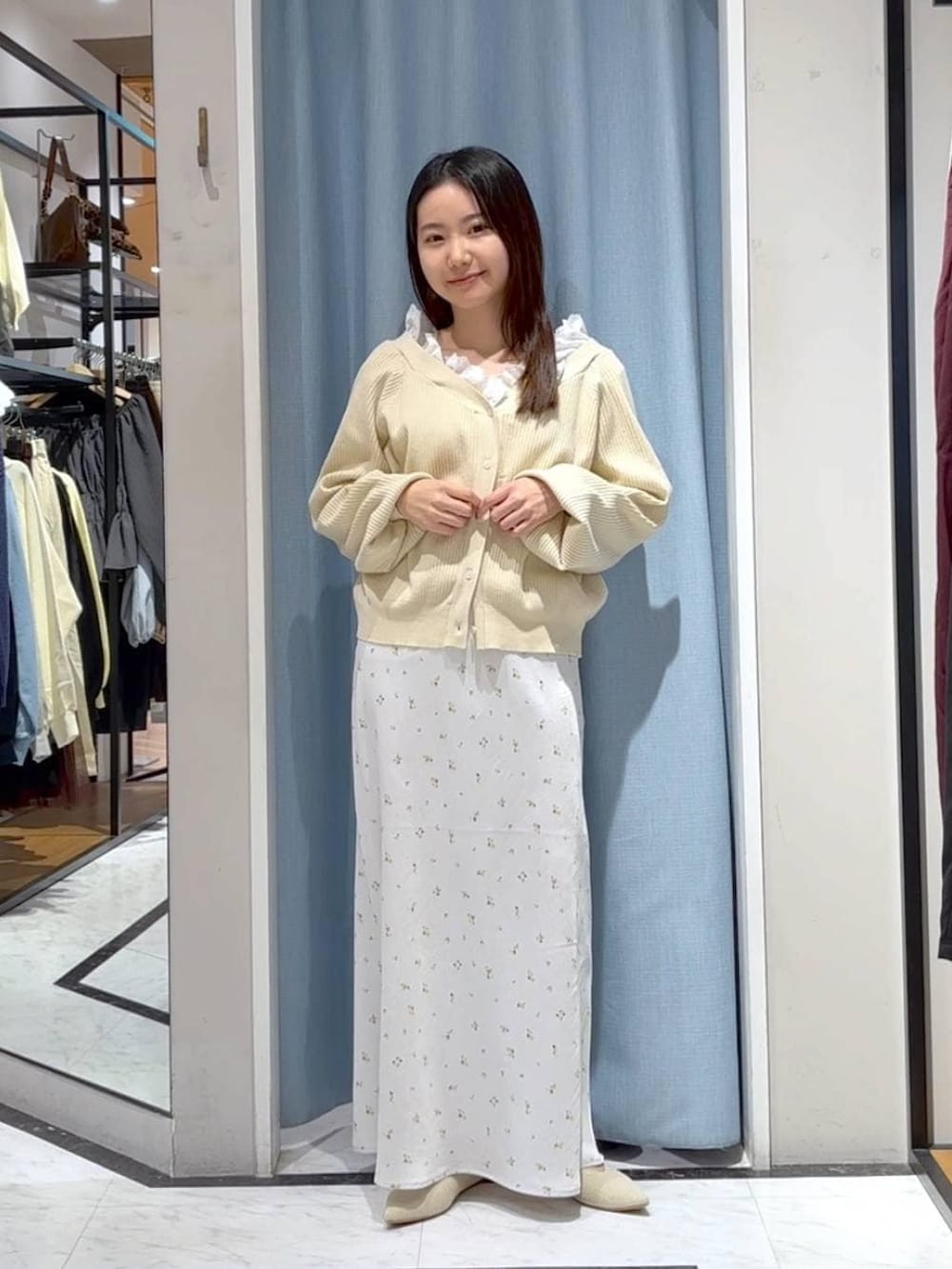 ホワイト系のスカート、ホワイト系のパンプス、ベージュ系のカーディガン/ボレロを着用したレディースの春コーディネートの4枚目の写真