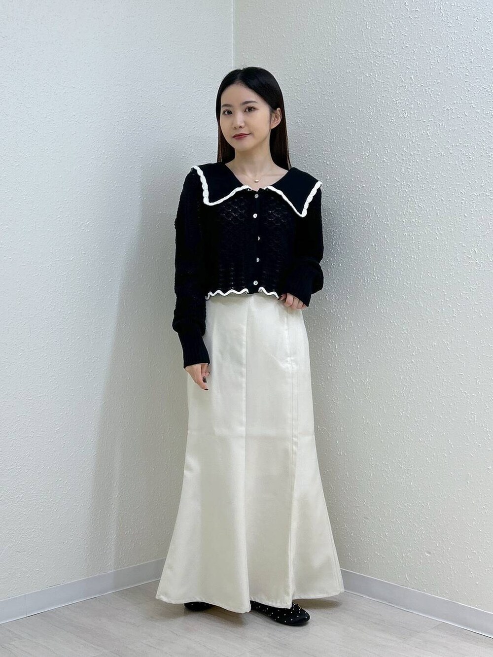 ホワイト系のスカート、ホワイト系のタンクトップ、ブラック系のバレエシューズを着用したレディースの秋コーディネートの5枚目の写真