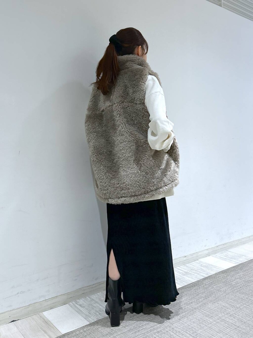 ホワイト系のブルゾン、ブラック系のパンプス、ブラック系のスカートを着用したレディースの冬コーディネートの6枚目の写真