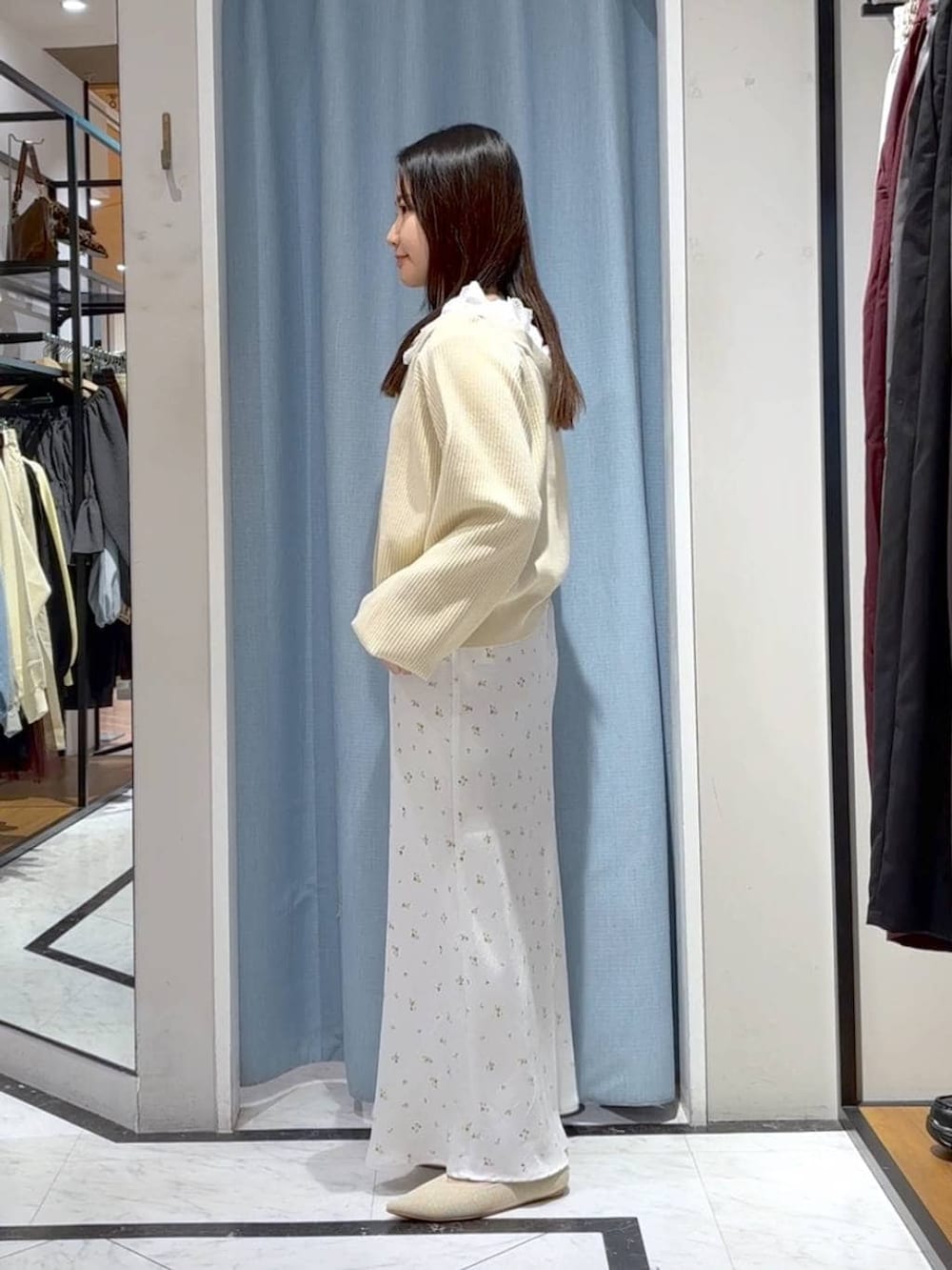 ホワイト系のスカート、ホワイト系のパンプス、ベージュ系のカーディガン/ボレロを着用したレディースの春コーディネートの5枚目の写真