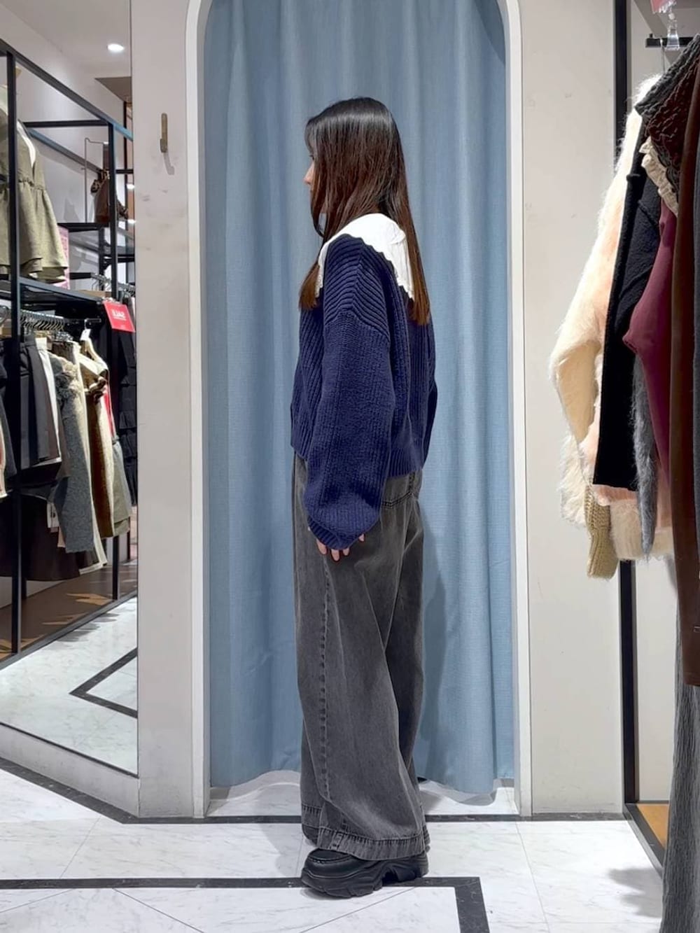 ブラック系のデニムパンツ、ブラック系のローファー、ブルー系のカーディガン/ボレロを着用したレディースの冬コーディネートの6枚目の写真