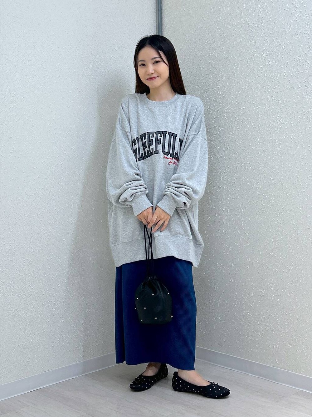 ブラック系のスカート、ブラック系のショルダーバッグ、ブラック系のバレエシューズを着用したレディースの秋コーディネートの4枚目の写真