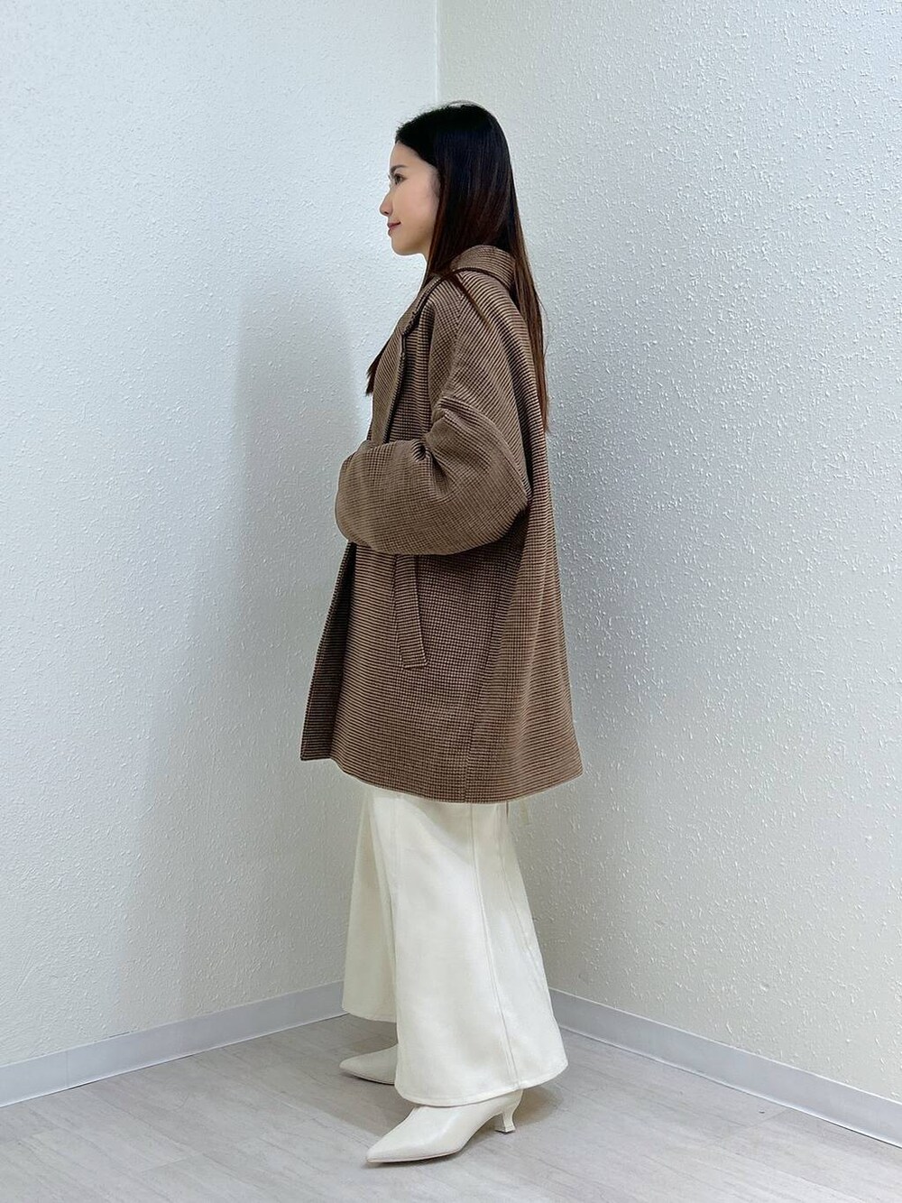 ホワイト系のスカート、ホワイト系のニット/セーター、その他のテーラードジャケットを着用したレディースの冬コーディネートの8枚目の写真