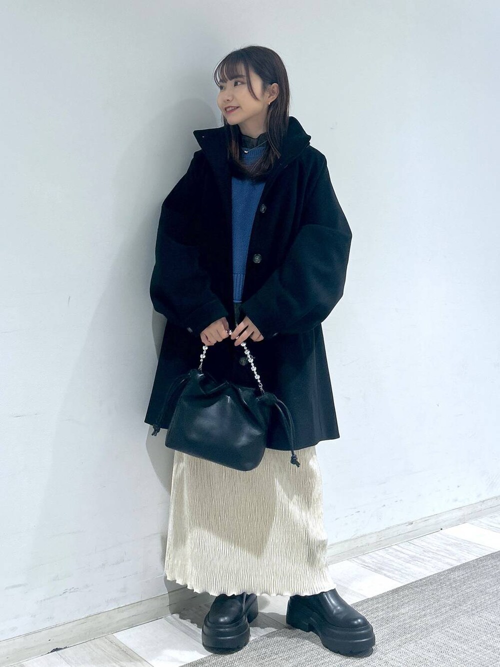 ブラック系のその他アウター、ブルー系のTシャツ/カットソー、ブラック系のブーツを着用したレディースの冬コーディネートの3枚目の写真