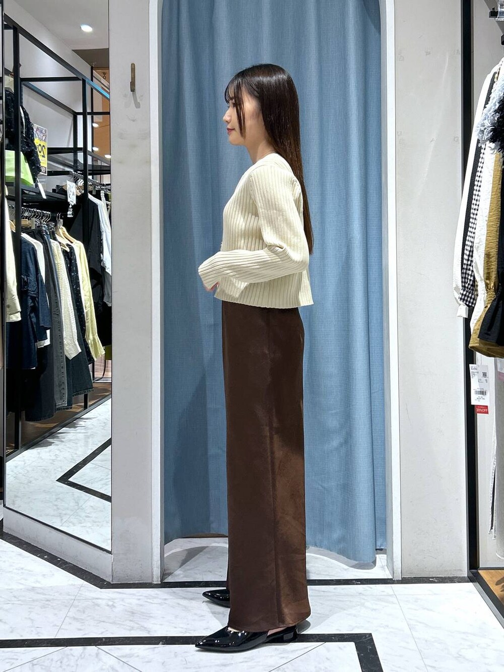 ホワイト系のカーディガン/ボレロ、ブラック系のパンプス、ゴールド系のタンクトップを着用したレディースの春コーディネートの8枚目の写真