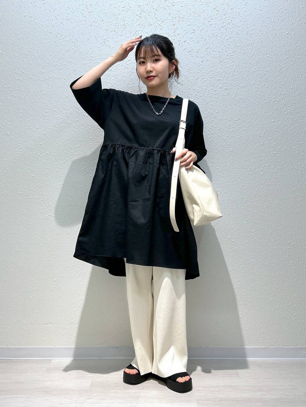 ブラック系のサンダル、ホワイト系のその他パンツ、ブラック系のTシャツ/カットソーを着用したレディースの春コーディネートの6枚目の写真