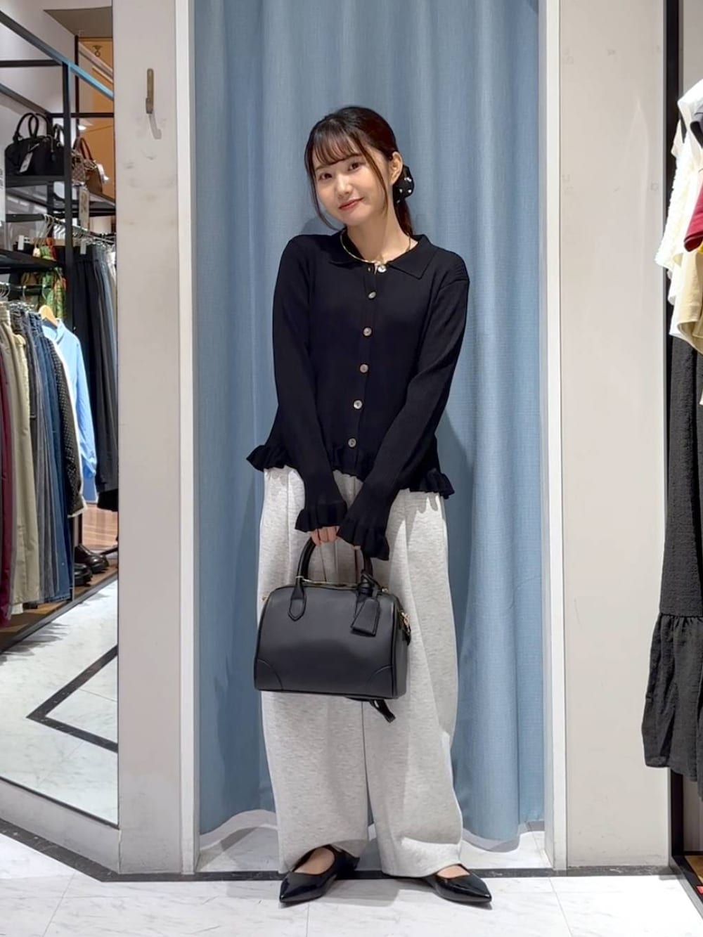 グレー系のスウェットパンツ、ブラック系のショルダーバッグ、ブラック系のニット/セーターを着用したレディースの秋コーディネートの3枚目の写真